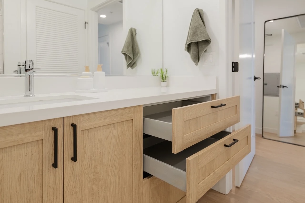 White oak bathroom vanity with a quartz top and full-width mirror